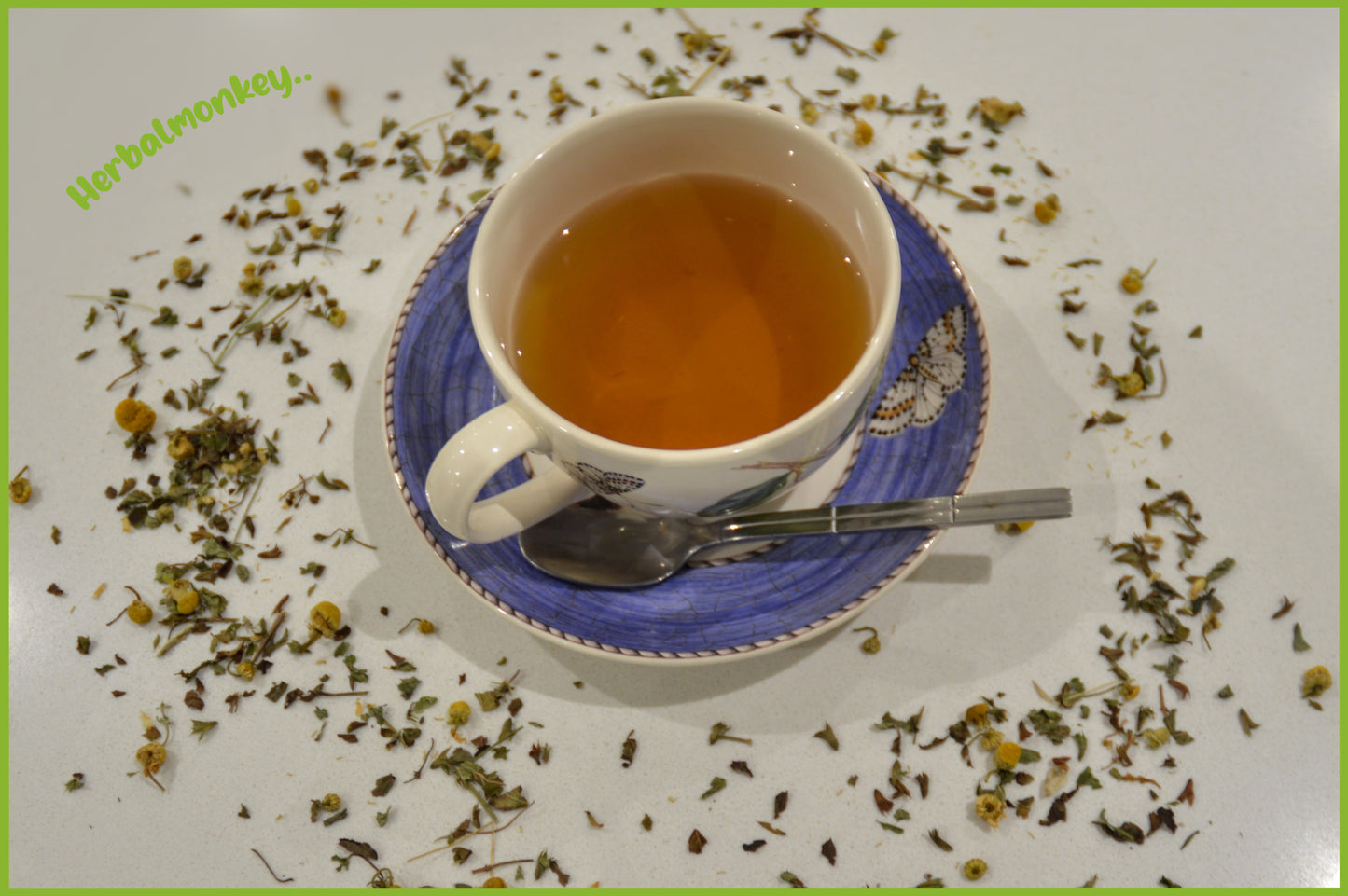 Chamomile & Lemon Balm tea with loose botanicals beside cup Herbal Monkey