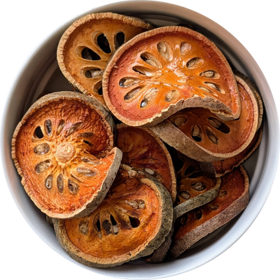 Dried Bael Fruit slices and a warm amber‑coloured bael tea, traditionally brewed as Thai Nam Matoom