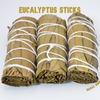 Close-up of three hand-tied Eucalyptus smudge sticks on a white background