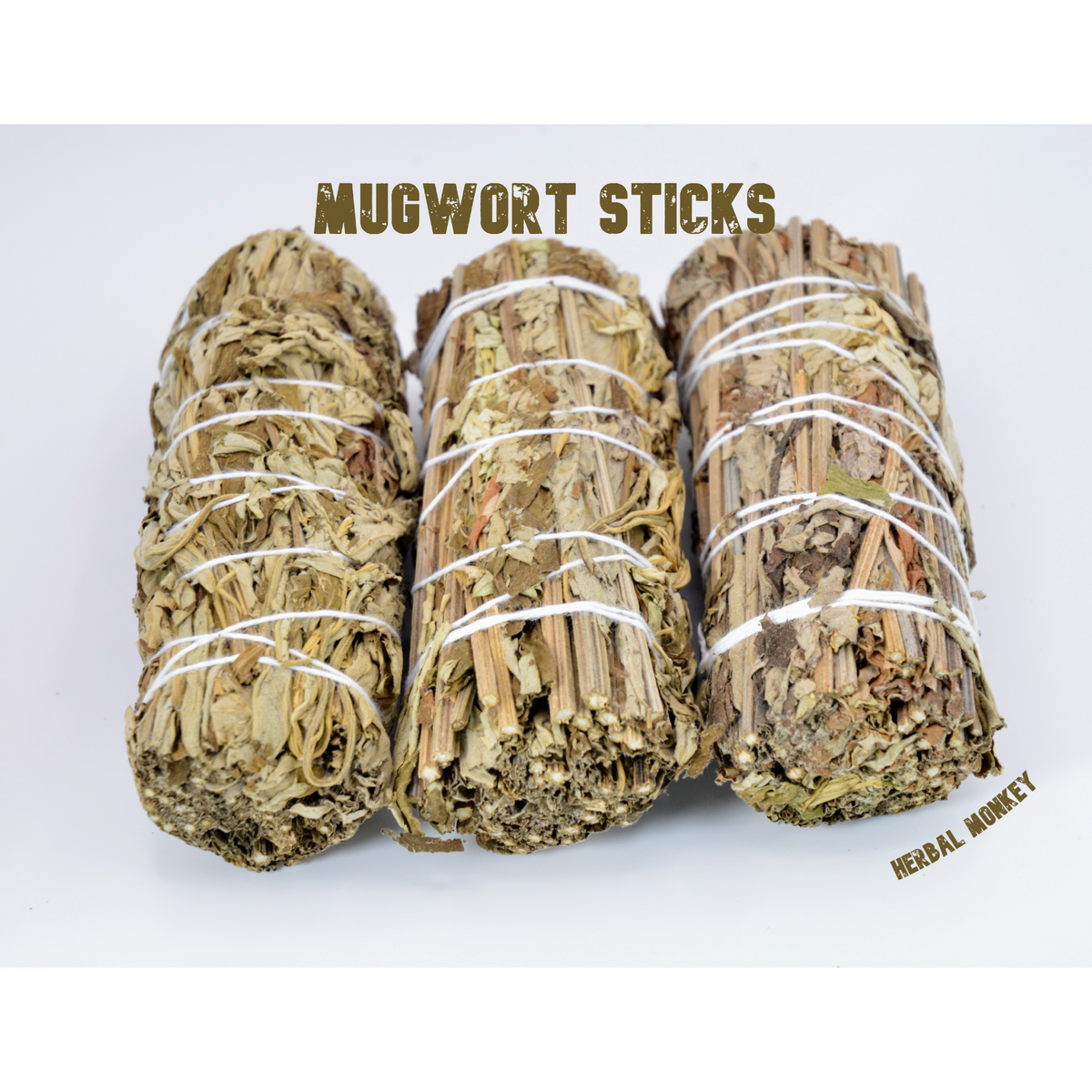 Close-up of three hand-tied Mugwort smudge sticks showing the dried leaves and stems