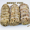 Three Mugwort smudge sticks (Artemisia vulgaris) hand tied with white cotton string on a white background